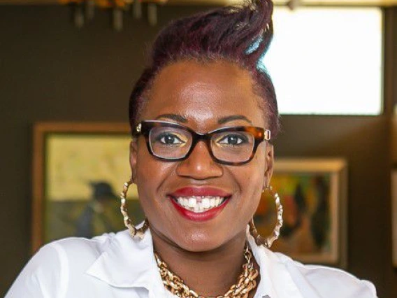 brown woman with black hair and glasses