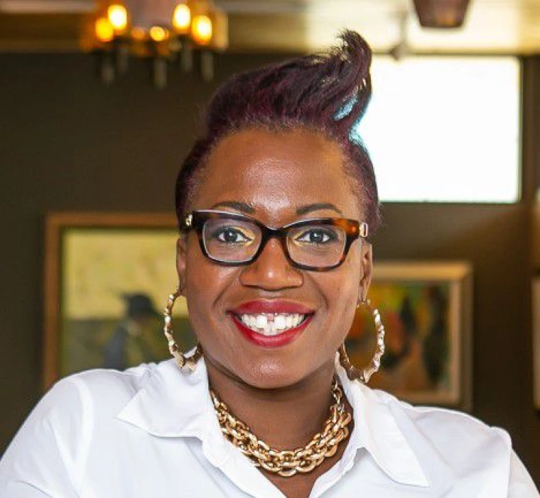 brown woman with black hair and glasses